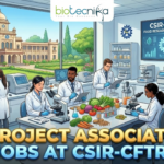 Project Associate Jobs at CSIR-CFTRI Explore Latest Life Science Jobs. An illustration for a job advertisement featuring the "biotecnika Global" logo at the top center. The main scene is a bustling, modern food science laboratory where diverse researchers in lab coats are working with microscopes, analytical instruments, and various food samples like vegetables and grains. A large screen in the background reads "CSIR-CFTRI: FOOD RESEARCH & INNOVATION". Through large windows, the grand campus building of CSIR-CFTRI is visible under a clear sky. Large, bold gold and blue text across the bottom reads "PROJECT ASSOCIATE JOBS AT CSIR-CFTRI".