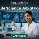 BSc Life Science Job at Fortrea Opportunity You Shouldn’t Miss. A promotional featured image for a job page. At the top, text reads: "biotecnika Your Bio Resource" and the headline "BSc Life Science Job at Fortrea". The image depicts a smiling female scientist of Indian heritage, in a white lab coat and nitrile gloves, using a multichannel pipette to work with a 96-well plate at a modern laboratory bench. The background features three large, curved monitors displaying complex data visualizations like protein structures, molecular pathways, and generic clinical trial progress charts. Foreground elements include binders labeled "Clinical Studies" and "R&D reports", microcentrifuge tubes, and multiple pipettes. At the bottom center is a teal "APPLY NOW" button.