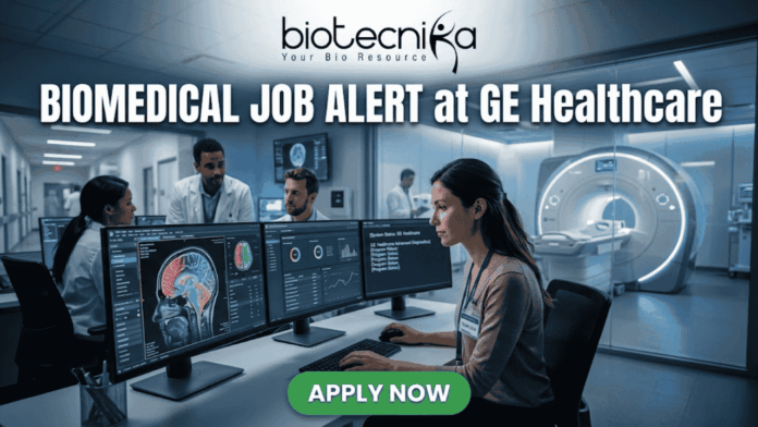 Biomedical Job at GE Healthcare Clinical Specialist Role Biomedical Job at GE Healthcare Clinical Specialist Role. A professional featured image for a Biomedical Job Alert at GE Healthcare. The Biotecnika logo is positioned at the top center. The main scene shows a female biomedical professional sitting at a modern workstation with dual monitors displaying high-resolution brain scans (MRI/CT) and complex data analytics. In the background, other colleagues in white lab coats are visible in a brightly lit, high-tech clinical environment. Behind a glass partition, a large, state-of-the-art medical imaging scanner is featured. At the bottom, a prominent green button reads "APPLY NOW." The image uses a professional blue and white color palette to emphasize a cutting-edge healthcare setting.