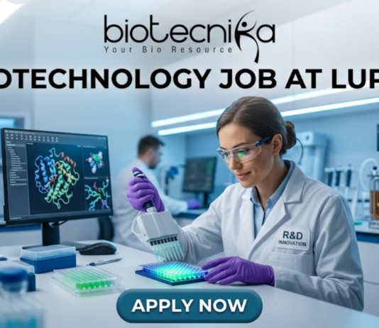 Biotechnology Job at Lupin Postgraduate Candidates Apply Now. A professional featured image for a biotechnology job opening at Lupin. The scene depicts a female scientist in a modern, high-tech laboratory wearing a white lab coat and safety gear, working with a multichannel pipette and a multi-well plate. The background shows computer monitors with molecular structures and advanced lab equipment. The image includes the Biotecnika logo at the top center, the bold text "BIOTECHNOLOGY JOB AT LUPIN" in the middle, and a prominent "APPLY NOW" button at the bottom.