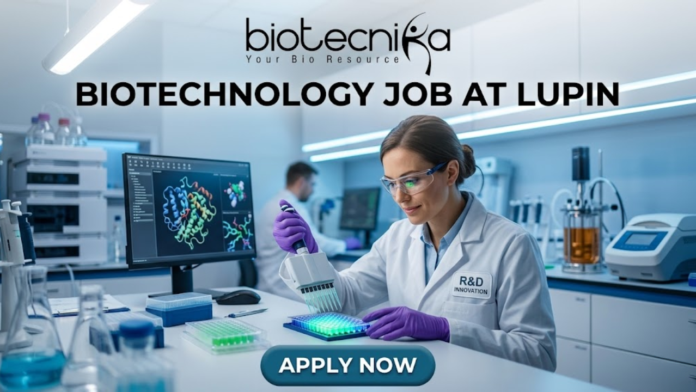 Biotechnology Job at Lupin Postgraduate Candidates Apply Now Biotechnology Job at Lupin Postgraduate Candidates Apply Now. A professional featured image for a biotechnology job opening at Lupin. The scene depicts a female scientist in a modern, high-tech laboratory wearing a white lab coat and safety gear, working with a multichannel pipette and a multi-well plate. The background shows computer monitors with molecular structures and advanced lab equipment. The image includes the Biotecnika logo at the top center, the bold text "BIOTECHNOLOGY JOB AT LUPIN" in the middle, and a prominent "APPLY NOW" button at the bottom.