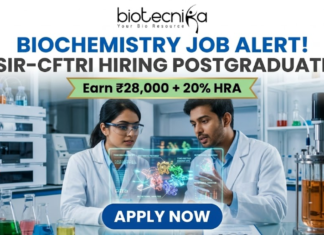 Biochemistry Job Alert! CSIR-CFTRI Hiring Postgraduates | Earn ₹28,000 + 20% HRA CSIR-CFTRI Hiring for Biochemistry Job Earn Upto ₹28,000. A professional and vibrant featured image advertisement for a biochemistry job alert at CSIR-CFTRI, created for Biotecnika. The scene features two young scientists (a man and a woman) in white lab coats and safety goggles, intensely discussing a holographic 3D molecular structure displayed over a lab bench. The background is a brightly lit, modern food science laboratory equipped with advanced bioreactors and analytical instruments. The Biotecnika logo is at the top center. The main text reads "BIOCHEMISTRY JOB ALERT! CSIR-CFTRI HIRING POSTGRADUATES" with a gold ribbon tagline below stating "Earn ₹28,000 + 20% HRA." A large, blue "APPLY NOW" button is positioned at the bottom.