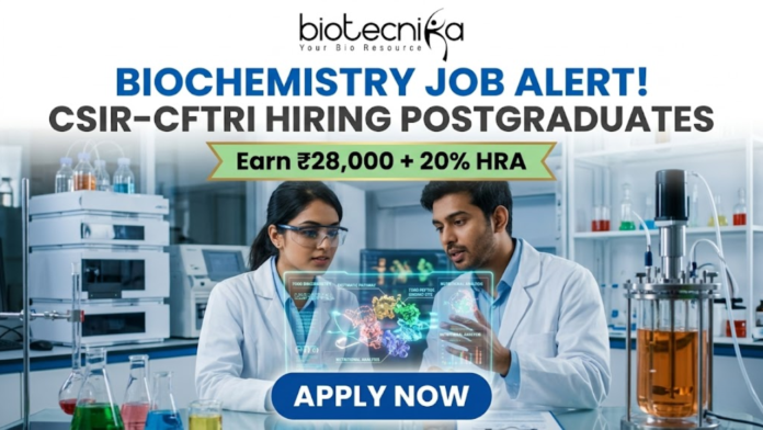 CSIR-CFTRI Hiring for Biochemistry Job Earn Upto ₹28,000 CSIR-CFTRI Hiring for Biochemistry Job Earn Upto ₹28,000. A professional and vibrant featured image advertisement for a biochemistry job alert at CSIR-CFTRI, created for Biotecnika. The scene features two young scientists (a man and a woman) in white lab coats and safety goggles, intensely discussing a holographic 3D molecular structure displayed over a lab bench. The background is a brightly lit, modern food science laboratory equipped with advanced bioreactors and analytical instruments. The Biotecnika logo is at the top center. The main text reads "BIOCHEMISTRY JOB ALERT! CSIR-CFTRI HIRING POSTGRADUATES" with a gold ribbon tagline below stating "Earn ₹28,000 + 20% HRA." A large, blue "APPLY NOW" button is positioned at the bottom.