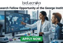 Don’t Miss This Research Fellow Opportunity at George Institute – Perfect Fresher’s Job in Life Sciences! Research Fellow at George Institute | Fresher's Job India. A professional featured job image with the Biotecnika logo at the top and a bold headline reading "Research Fellow Opportunity at the George Institute." The central scene features a female scientist in a white lab coat pointing to a large digital monitor displaying global health maps, data analytics, and chronic disease trends, while a male colleague looks on. The setting is a modern, high-tech laboratory equipped with a microscope and glassware. At the bottom center, there is a prominent green "APPLY NOW" button.