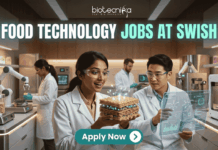 Exciting Food Technology Jobs Alert at Swish | Don't Miss This Opporunity. A unique and futuristic featured image for "Food Technology Jobs at Swish." Two scientists in a high-tech food lab are examining a glowing, layered "tech-food" sample. The lab is equipped with 3D food printers and robotic arms. The Biotecnika logo is at the top, and a clean "Apply Now" button with an arrow is at the bottom center.