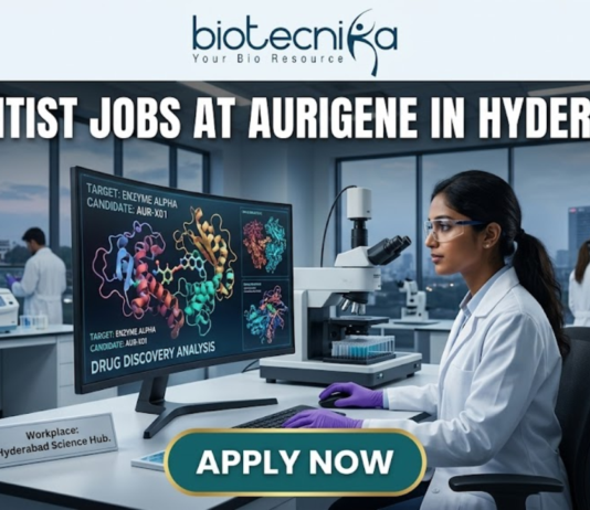 Scientist Jobs at Aurigene in Hyderabad. A high-quality, professional featured image for "Scientist Jobs at Aurigene in Hyderabad." The scene depicts a female scientist in a white lab coat and purple gloves working in a sophisticated laboratory. She is focused on a large monitor displaying vibrant 3D molecular structures under the heading "Drug Discovery Analysis." Her desk features a modern microscope and a small plaque that says "Workplace: Hyderabad Science Hub." In the background, the iconic Charminar is visible through a large window, establishing the Hyderabad setting. The Biotecnika logo is positioned at the top center, the job title is in bold white lettering, and a prominent "APPLY NOW" button is at the bottom.