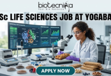 Freshers Wanted! BSc Life Sciences Job at Yogabar | Apply Now BSc Life Sciences Job at Yogabar Careers | Apply Now. A high-quality, professional featured image for a "BSc Life Sciences Job at Yogabar." The scene depicts a female food scientist in a white lab coat and safety goggles in a bright, modern food science laboratory. She is carefully examining a healthy snack bar under a professional microscope. On her desk are raw ingredients like chia seeds, flax seeds, and berries, alongside advanced lab equipment like a moisture analyzer. A large computer monitor in the background displays complex "Nutritional Profile Analysis" and 3D protein structures. The Biotecnika logo is at the top, the main job title is in bold black text, and a prominent "APPLY NOW" button is at the bottom.