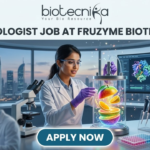 Fruzyme Biotech India Hiring Microbiologist Job | Freshers Eligible Apply Now! Microbiologist Job at Fruzyme Biotech India | Freshers Eligible. A professional and vibrant featured image for a "Microbiologist Job at Fruzyme Biotech India." The image depicts a female scientist in a high-tech lab working with a unique bioreactor containing glowing, levitating fruit slices, symbolizing specialized enzyme research. Modern lab equipment, data-filled monitors showing "Fruit Polysaccharide Enzyme Pathways," and a city skyline are visible in the background. The Biotecnika logo is positioned at the top center, the main title is in bold black text, and a prominent "APPLY NOW" button is at the bottom.