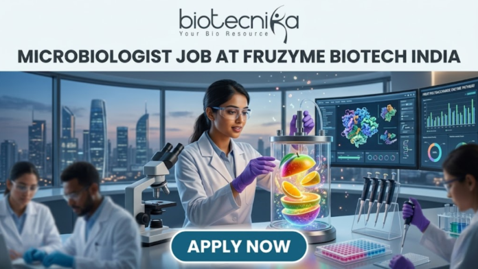 Microbiologist Job at Fruzyme Biotech India | Freshers Eligible Microbiologist Job at Fruzyme Biotech India | Freshers Eligible. A professional and vibrant featured image for a "Microbiologist Job at Fruzyme Biotech India." The image depicts a female scientist in a high-tech lab working with a unique bioreactor containing glowing, levitating fruit slices, symbolizing specialized enzyme research. Modern lab equipment, data-filled monitors showing "Fruit Polysaccharide Enzyme Pathways," and a city skyline are visible in the background. The Biotecnika logo is positioned at the top center, the main title is in bold black text, and a prominent "APPLY NOW" button is at the bottom.