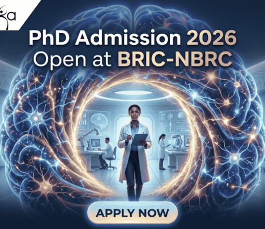 PhD Admission 2026 Open at BRIC-NBRC | Apply Online Today. A featured image for PhD Admission 2026 at BRIC-NBRC. The image shows a female scientist in a white lab coat standing in a futuristic laboratory, surrounded by a large, glowing holographic human brain with intricate neural pathways. The text "PhD Admission 2026 Open at BRIC-NBRC" is prominently displayed at the top center. The Biotecnika logo is in the top left corner, and a blue "APPLY NOW" button is positioned at the bottom. Background researchers work in a high-tech neurobiology research environment.