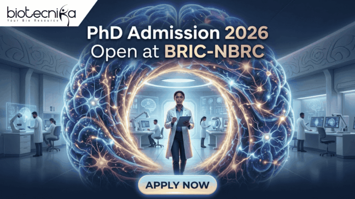 PhD Admission 2026 Open at BRIC-NBRC | Apply Online Today PhD Admission 2026 Open at BRIC-NBRC | Apply Online Today. A featured image for PhD Admission 2026 at BRIC-NBRC. The image shows a female scientist in a white lab coat standing in a futuristic laboratory, surrounded by a large, glowing holographic human brain with intricate neural pathways. The text "PhD Admission 2026 Open at BRIC-NBRC" is prominently displayed at the top center. The Biotecnika logo is in the top left corner, and a blue "APPLY NOW" button is positioned at the bottom. Background researchers work in a high-tech neurobiology research environment.