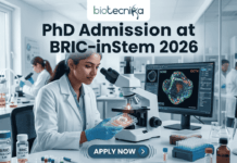 PhD Admission at BRIC-inStem 2026 | JRF-Based Entry + Cutting-Edge Stem Cell Research Opportunity! A high-resolution featured image for PhD Admission at BRIC-inStem 2026. The image depicts a modern, realistic biotechnology laboratory where a female scientist of Indian descent, wearing a lab coat and safety goggles, is carefully examining a multi-well plate. Beside her, a computer monitor displays a vibrant, high-detail microscopic image of a stem cell labeled with genetic markers. The Biotecnika logo is positioned at the top center, and a prominent "APPLY NOW" button is located at the bottom.