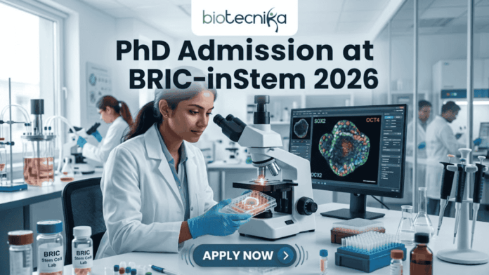 PhD Admission at BRIC-inStem 2026 | Apply Now A high-resolution featured image for PhD Admission at BRIC-inStem 2026. The image depicts a modern, realistic biotechnology laboratory where a female scientist of Indian descent, wearing a lab coat and safety goggles, is carefully examining a multi-well plate. Beside her, a computer monitor displays a vibrant, high-detail microscopic image of a stem cell labeled with genetic markers. The Biotecnika logo is positioned at the top center, and a prominent "APPLY NOW" button is located at the bottom.