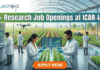 25+ Research Job Openings at ICAR-IARI – Online Interview . A featured image for a job advertisement titled "25+ Research Job Openings at ICAR-IARI." The image depicts a futuristic, high-tech agricultural laboratory set within a large glass greenhouse. In the foreground, a female and a male scientist in white lab coats are working at a digital station, examining young green plants. Digital screens display DNA sequences and plant growth data. In the background, a drone flies over rows of crops, and through the glass walls, traditional farmers are seen working in lush green fields. The Biotecnika logo is at the top left, and a prominent orange "APPLY NOW" button is centered at the bottom.