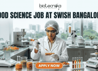 Food Science Job Alert – Food Technologist Role at Swish Bangalore Food Science Job at Swish Bangalore. A clean, modern featured image showing a food scientist in a sterile lab environment using a precision pipette on a nutrient-rich food prototype. The lab is equipped with advanced food testing machinery and colorful test tubes. The city skyline of Bangalore is visible through the window. The Biotecnika logo is at the top, and an orange "Apply Now" button is at the bottom.