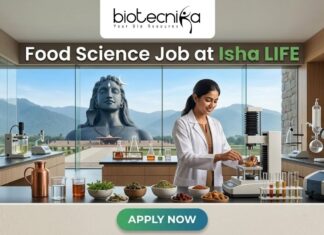 Exciting Food Science Job Alert: Join Isha LIFE as R&D Specialist Today!! Food Science Job at Isha LIFE R&D Specialist Role. A featured image for a job posting titled "Food Science Job at Isha LIFE." The image displays a professional female scientist in a white lab coat working in a modern, high-tech food laboratory. On the lab counter, there are various bowls of natural grains, herbs, and scientific testing equipment. Through the large glass windows in the background, the iconic Adi Yogi statue is visible against a scenic mountain landscape, reflecting the Isha Foundation theme. The Biotecnika logo is positioned at the top center, and a prominent green "APPLY NOW" button is located at the bottom.