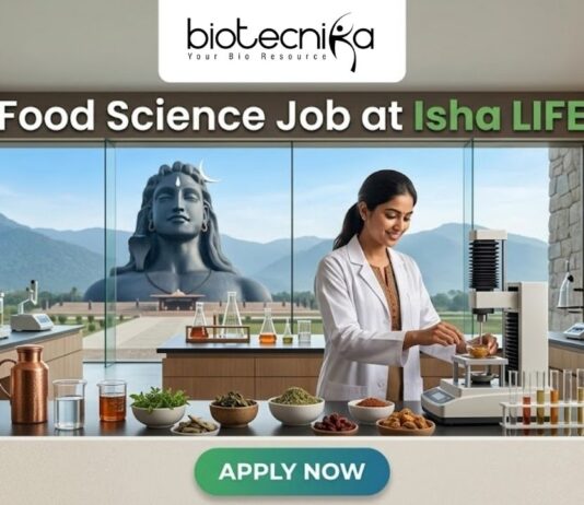 Food Science Job at Isha LIFE R&D Specialist Role. A featured image for a job posting titled "Food Science Job at Isha LIFE." The image displays a professional female scientist in a white lab coat working in a modern, high-tech food laboratory. On the lab counter, there are various bowls of natural grains, herbs, and scientific testing equipment. Through the large glass windows in the background, the iconic Adi Yogi statue is visible against a scenic mountain landscape, reflecting the Isha Foundation theme. The Biotecnika logo is positioned at the top center, and a prominent green "APPLY NOW" button is located at the bottom.