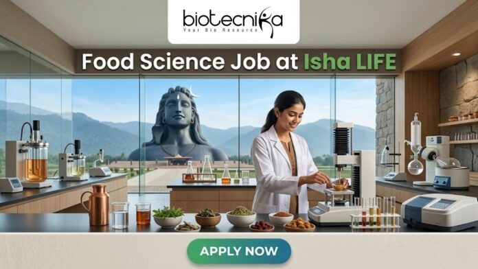 Food Science Job at Isha LIFE R&D Specialist Role Food Science Job at Isha LIFE R&D Specialist Role. A featured image for a job posting titled "Food Science Job at Isha LIFE." The image displays a professional female scientist in a white lab coat working in a modern, high-tech food laboratory. On the lab counter, there are various bowls of natural grains, herbs, and scientific testing equipment. Through the large glass windows in the background, the iconic Adi Yogi statue is visible against a scenic mountain landscape, reflecting the Isha Foundation theme. The Biotecnika logo is positioned at the top center, and a prominent green "APPLY NOW" button is located at the bottom.