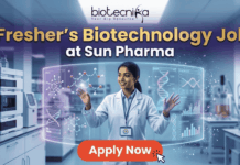 Fresher’s Job Alert! Biotechnology Job at Sun Pharma | Don’t Miss Out! Fresher's Job Alert! Biotechnology Job at Sun Pharma Don’t Miss Out! A promotional job banner with the Biotecnika logo at the top. The headline text is "Fresher's Biotechnology Job" and "at Sun Pharma". A smiling young woman in a lab coat stands in a futuristic laboratory, interacting with floating holographic screens. The screens display molecular structures labeled "Drug Discovery" and "Lead Identification," and a DNA helix with graphs labeled "DNA" and "Data Discovery". A large red button at the bottom says "Apply Now". The background shows complex lab equipment.