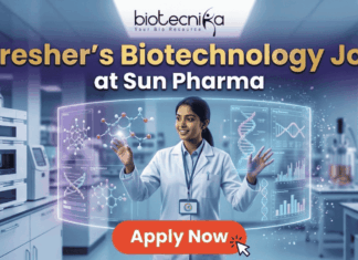 Fresher’s Job Alert! Biotechnology Job at Sun Pharma | Don’t Miss Out! Fresher's Job Alert! Biotechnology Job at Sun Pharma Don’t Miss Out! A promotional job banner with the Biotecnika logo at the top. The headline text is "Fresher's Biotechnology Job" and "at Sun Pharma". A smiling young woman in a lab coat stands in a futuristic laboratory, interacting with floating holographic screens. The screens display molecular structures labeled "Drug Discovery" and "Lead Identification," and a DNA helix with graphs labeled "DNA" and "Data Discovery". A large red button at the bottom says "Apply Now". The background shows complex lab equipment.