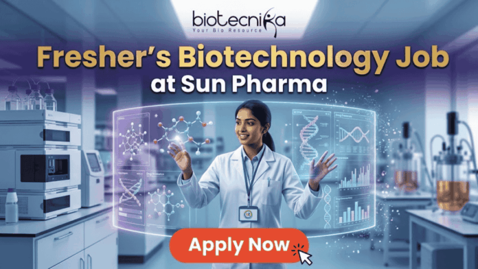 Fresher's Job Alert! Biotechnology Job at Sun Pharma Don’t Miss Out! Fresher's Job Alert! Biotechnology Job at Sun Pharma Don’t Miss Out! A promotional job banner with the Biotecnika logo at the top. The headline text is "Fresher's Biotechnology Job" and "at Sun Pharma". A smiling young woman in a lab coat stands in a futuristic laboratory, interacting with floating holographic screens. The screens display molecular structures labeled "Drug Discovery" and "Lead Identification," and a DNA helix with graphs labeled "DNA" and "Data Discovery". A large red button at the bottom says "Apply Now". The background shows complex lab equipment.
