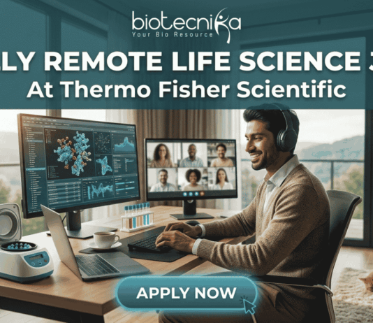 Fully Remote Life Science Job at Thermo Fisher Scientific – Global Opportunity! A professional, attractive, and unique featured image for a "Fully Remote Life Science Job At Thermo Fisher Scientific," recruited through biotecnika. A smiling South Asian man with headphones types on a laptop at a large wooden desk in a bright home office. His desk features monitors displaying 3D molecular structures, data charts, and a group video conference call. Automated lab equipment and reagent tubes are on the desk. A large window overlooks a scenic mountainous view, with a tabby cat asleep nearby. Header text reads 'FULLY REMOTE LIFE SCIENCE JOB At Thermo Fisher Scientific'. The 'biotecnika Your Bio Resource' logo is at the top. A prominent 'APPLY NOW' button is at the bottom center. No Thermo Fisher Scientific company logo graphic is present.