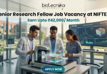 High Paying Senior Research Fellow Job Vacancy at NIFTEM | Earn Upto ₹42,000/ Month High Paying Senior Research Fellow Job Vacancy at NIFTEM Earn Upto ₹42,000 Month. A professional and vibrant featured image for a "Senior Research Fellow Job Vacancy at NIFTEM." The scene showcases three diverse researchers in white lab coats working in a sunlit, state-of-the-art food technology laboratory. They are gathered around an advanced imaging device analyzing a 3D-rendered food sample. A large digital monitor in the background displays complex data visualizations and structural models. The Biotecnika logo is positioned at the top center. The primary text reads "Senior Research Fellow Job Vacancy at NIFTEM" with a sub-headline "Earn Upto ₹42,000/ Month." A sleek, glowing "APPLY NOW" button is located at the bottom.