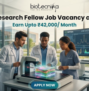 High Paying Senior Research Fellow Job Vacancy at NIFTEM | Earn Upto ₹42,000/ Month High Paying Senior Research Fellow Job Vacancy at NIFTEM Earn Upto ₹42,000 Month. A professional and vibrant featured image for a "Senior Research Fellow Job Vacancy at NIFTEM." The scene showcases three diverse researchers in white lab coats working in a sunlit, state-of-the-art food technology laboratory. They are gathered around an advanced imaging device analyzing a 3D-rendered food sample. A large digital monitor in the background displays complex data visualizations and structural models. The Biotecnika logo is positioned at the top center. The primary text reads "Senior Research Fellow Job Vacancy at NIFTEM" with a sub-headline "Earn Upto ₹42,000/ Month." A sleek, glowing "APPLY NOW" button is located at the bottom.