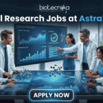 Hiring Now! Clinical Research Jobs at AstraZeneca for Life Science Graduates! A professional featured image for "Clinical Research Jobs at AstraZeneca." It shows a group of medical researchers in lab coats gathered around a large interactive touch-table displaying clinical trial data, graphs, and 3D molecular models. The Biotecnika logo is at the top, and a sleek "Apply Now" button is at the bottom.