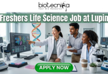 Latest Life Science Job at Lupin | Freshers Welcome to Apply Latest Life Science Job at Lupin Freshers Welcome to Apply. A professional 1280x720 featured image for a "Freshers Life Science Job at Lupin." The Biotecnika logo is placed at the top center. The main heading reads "Freshers Life Science Job at Lupin" in a bold, clean font. The background features a realistic, high-tech laboratory where three enthusiastic young scientists—two women and one man—are collaborating and smiling. One scientist is pointing toward a large monitor displaying detailed 3D protein structures and genomic data. The lab environment is bright and modern, filled with scientific equipment like microscopes and pipettes. At the bottom, a prominent green "APPLY NOW" button encourages viewers to take action.