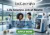 Life Science Job at Nestlé Nutrition Officer Role. A professional featured image titled "Life Science Job at Nestlé". The image showcases the Biotecnika logo at the top and a vibrant green "APPLY NOW" button at the bottom. The background depicts a bright, high-tech laboratory where two scientists—a woman and a man—are smiling and collaborating over a futuristic holographic display of molecular structures. Other researchers and advanced laboratory equipment are visible in the sleek, modern setting.