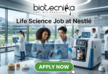 Dream Life Science Job at Nestlé | BSc Candidates Apply Before Deadline! Life Science Job at Nestlé Nutrition Officer Role. A professional featured image titled "Life Science Job at Nestlé". The image showcases the Biotecnika logo at the top and a vibrant green "APPLY NOW" button at the bottom. The background depicts a bright, high-tech laboratory where two scientists—a woman and a man—are smiling and collaborating over a futuristic holographic display of molecular structures. Other researchers and advanced laboratory equipment are visible in the sleek, modern setting.