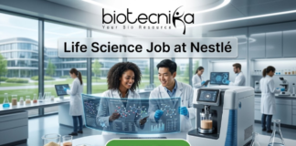 Life Science Job at Nestlé Nutrition Officer Role. A professional featured image titled "Life Science Job at Nestlé". The image showcases the Biotecnika logo at the top and a vibrant green "APPLY NOW" button at the bottom. The background depicts a bright, high-tech laboratory where two scientists—a woman and a man—are smiling and collaborating over a futuristic holographic display of molecular structures. Other researchers and advanced laboratory equipment are visible in the sleek, modern setting.