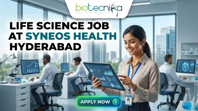 Life Science Job at Syneos Health Hyderabad Life Science Job at Syneos Health Hyderabad. A career advertisement banner for a life science job at Syneos Health in Hyderabad, presented by Biotecnika Global. The banner features a smiling woman in a lab coat and safety glasses, holding and pointing at a tablet that displays data charts and a molecular structure. She is standing in a modern office and laboratory setting, with large windows overlooking a city skyline. Other researchers in lab coats are seated at desks in the background, working on computer monitors. The "biotecnika Global Hiring and Neurnic Solutions" logo is at the top, and a green "Apply now" button with an arrow is at the bottom.