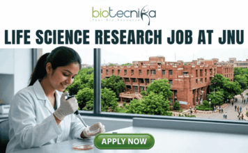 Life Science Research Job At Jawaharlal Nehru University (JNU) | Apply Now! Life Science Research Job At Jawaharlal Nehru University (JNU). A high-quality featured image for a job page (1280x720) with the "biotecnika" logo and text at the top. Large, clear text reads: "MSc LIFE SCIENCE FRESHERS JOB at Thermo Fisher Scientific". Imagery shows a diverse group of four young scientists in lab coats and stylish casual wear collaborating enthusiastically around a transparent screen displaying a colourful 3D molecular model, within a sophisticated, sunlit laboratory. The background features unbranded lab equipment and natural light. A distinct green rectangular button at the bottom center has the text "Apply Now", with smaller text "MSc LIFE SCIENCE FRESHERS JOB" below it. The entire top section is framed by a deep teal textured banner. The scene is realistic, attractive, and conveys energy and discovery, suitable for going viral.