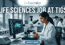 Urgent Hiring! High-Paying Life Sciences Jobs at TIGS – Apply Before April 27! Life Sciences Job at TIGS Research Scientist & Support Roles. A professional featured image (1280x720) for a Life Sciences Job at TIGS. The scene depicts a modern, high-tech laboratory where a female scientist of South Asian descent is meticulously working with a microscope. To her left, a large computer monitor displays a glowing green digital 3D model of a mosquito overlaid with a DNA double helix, signifying genetic research. The Biotecnika logo is prominently placed at the top center. The text "LIFE SCIENCES JOB AT TIGS" is written in bold, white capital letters across the top. At the bottom center, there is a sleek, blue "APPLY NOW" button. The background shows a bright, clean research facility with other scientists in lab coats, creating an atmosphere of innovation and discovery.