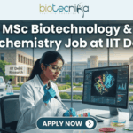 MSc Biotechnology & Biochemistry Job at IIT Delhi. A professional and realistic featured image for a job opening. At the top center is the Biotecnika Global logo, followed by large, bold text reading "MSc Biotechnology & Biochemistry Job at IIT Delhi." The central scene depicts a female researcher in a white lab coat working in a high-tech laboratory, using a pipette on colorful samples while viewing a 3D molecular structure on a large monitor. The background shows advanced lab equipment and a clear view of the IIT Delhi Research campus through large windows. At the bottom, there is a prominent teal button that says "APPLY NOW" with a white arrow icon.