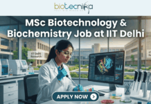 MSc Biotechnology & Biochemistry Job at IIT Delhi – Enzyme Assay Specialist Role Open Now! MSc Biotechnology & Biochemistry Job at IIT Delhi. A professional and realistic featured image for a job opening. At the top center is the Biotecnika Global logo, followed by large, bold text reading "MSc Biotechnology & Biochemistry Job at IIT Delhi." The central scene depicts a female researcher in a white lab coat working in a high-tech laboratory, using a pipette on colorful samples while viewing a 3D molecular structure on a large monitor. The background shows advanced lab equipment and a clear view of the IIT Delhi Research campus through large windows. At the bottom, there is a prominent teal button that says "APPLY NOW" with a white arrow icon.