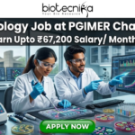 A vibrant microbiology lab featuring researchers working with Petri dishes and automated lab equipment. The tagline "Earn Upto ₹67,200 Salary/ Month" is displayed at the top. The Open Hand Monument is visible in the background. The Biotecnika logo is at the top, and a green "APPLY NOW" button is at the bottom.