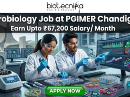 A vibrant microbiology lab featuring researchers working with Petri dishes and automated lab equipment. The tagline "Earn Upto ₹67,200 Salary/ Month" is displayed at the top. The Open Hand Monument is visible in the background. The Biotecnika logo is at the top, and a green "APPLY NOW" button is at the bottom.