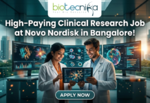 Novo Nordisk Hiring Clinical Data Scientist – High-Paying Clinical Research Job in Bangalore! Novo Nordisk Hiring Clinical Data Scientist – High-Paying Clinical Research Job in Bangalore! A promotional featured image for a job opening, featuring the headline "High-Paying Clinical Research Job at Novo Nordisk in Bangalore!" in bold white text at the top. The Biotecnika logo is positioned at the top center. The central visual shows two professional researchers—a woman and a man in white lab coats—smiling and collaborating while looking at a digital tablet that displays a glowing neural network. They are standing in a futuristic, high-tech laboratory equipped with large, curved monitors showing 3D protein structures and complex biological data. Through the large glass windows behind them, a modern city skyline is visible during a warm sunset. At the bottom center, there is a prominent, stylized "APPLY NOW" button.