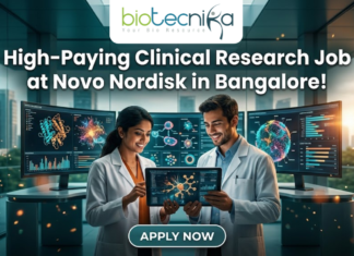 Novo Nordisk Hiring Clinical Data Scientist – High-Paying Clinical Research Job in Bangalore! Novo Nordisk Hiring Clinical Data Scientist – High-Paying Clinical Research Job in Bangalore! A promotional featured image for a job opening, featuring the headline "High-Paying Clinical Research Job at Novo Nordisk in Bangalore!" in bold white text at the top. The Biotecnika logo is positioned at the top center. The central visual shows two professional researchers—a woman and a man in white lab coats—smiling and collaborating while looking at a digital tablet that displays a glowing neural network. They are standing in a futuristic, high-tech laboratory equipped with large, curved monitors showing 3D protein structures and complex biological data. Through the large glass windows behind them, a modern city skyline is visible during a warm sunset. At the bottom center, there is a prominent, stylized "APPLY NOW" button.