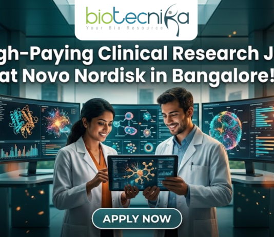 Novo Nordisk Hiring Clinical Data Scientist – High-Paying Clinical Research Job in Bangalore! Novo Nordisk Hiring Clinical Data Scientist – High-Paying Clinical Research Job in Bangalore! A promotional featured image for a job opening, featuring the headline "High-Paying Clinical Research Job at Novo Nordisk in Bangalore!" in bold white text at the top. The Biotecnika logo is positioned at the top center. The central visual shows two professional researchers—a woman and a man in white lab coats—smiling and collaborating while looking at a digital tablet that displays a glowing neural network. They are standing in a futuristic, high-tech laboratory equipped with large, curved monitors showing 3D protein structures and complex biological data. Through the large glass windows behind them, a modern city skyline is visible during a warm sunset. At the bottom center, there is a prominent, stylized "APPLY NOW" button.