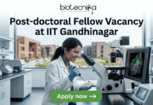 Post-doctoral Fellow Vacancy at IIT Gandhinagar. A sleek featured image for "Post-doctoral Fellow Vacancy at IIT Gandhinagar." It showcases a researcher pipetting samples in a laboratory with a university campus visible through the window. The Biotecnika logo is positioned at the top, with a green "Apply now" button at the bottom.