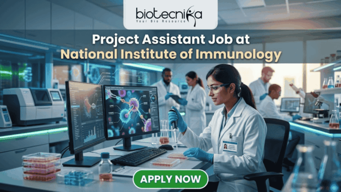 Project Assistant Job at National Institute of Immunology – Apply for Life Science Research Role Now! Project Assistant Job at National Institute of Immunology – Apply for Life Science Research Role Now! A promotional graphic for "biotecnika Your Bio Resource," set in a modern, busy laboratory environment. At the top center, the text "biotecnika Your Bio Resource" is displayed. Below it, the large headline "Project Assistant Job at National Institute of Immunology" is prominently featured in a white, sans-serif font. The main image shows a woman in a white lab coat, glasses, and blue gloves, using a pipette at a desk with dual computer monitors displaying complex molecular structures and scientific data. Other researchers work in the background. A large green button at the bottom contains the text "APPLY NOW". Various lab equipment is visible, and the overall color scheme is in blues, greens, white, and gold.