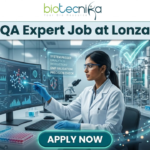 Limited Openings! QA Expert Job at Lonza Careers Hyderabad – Apply Fast! QA Job at Lonza Careers | QA Expert Hyderabad Role. A professional promotional image for a "QA Expert Job at Lonza" featuring the Biotecnika logo at the top. The scene depicts a female scientist in a white lab coat working in a state-of-the-art biotechnology facility. She is analyzing molecular data on a large computer monitor while a glowing holographic overlay displays a large green checkmark and text such as "GMP VALIDATION" and "SYSTEM PASSED." The background shows modern stainless steel bioreactors and laboratory equipment, emphasizing a high-standard Quality Assurance environment. A prominent teal "APPLY NOW" button is positioned at the bottom center.
