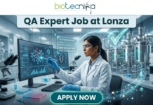 Limited Openings! QA Expert Job at Lonza Careers Hyderabad – Apply Fast! QA Job at Lonza Careers | QA Expert Hyderabad Role. A professional promotional image for a "QA Expert Job at Lonza" featuring the Biotecnika logo at the top. The scene depicts a female scientist in a white lab coat working in a state-of-the-art biotechnology facility. She is analyzing molecular data on a large computer monitor while a glowing holographic overlay displays a large green checkmark and text such as "GMP VALIDATION" and "SYSTEM PASSED." The background shows modern stainless steel bioreactors and laboratory equipment, emphasizing a high-standard Quality Assurance environment. A prominent teal "APPLY NOW" button is positioned at the bottom center.