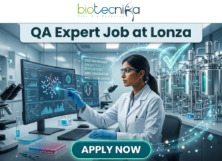 Limited Openings! QA Expert Job at Lonza Careers Hyderabad – Apply Fast! QA Job at Lonza Careers | QA Expert Hyderabad Role. A professional promotional image for a "QA Expert Job at Lonza" featuring the Biotecnika logo at the top. The scene depicts a female scientist in a white lab coat working in a state-of-the-art biotechnology facility. She is analyzing molecular data on a large computer monitor while a glowing holographic overlay displays a large green checkmark and text such as "GMP VALIDATION" and "SYSTEM PASSED." The background shows modern stainless steel bioreactors and laboratory equipment, emphasizing a high-standard Quality Assurance environment. A prominent teal "APPLY NOW" button is positioned at the bottom center.