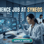 Top Life Science Job at Syneos Health – Central Monitor Role Hiring Now! Life Science Job at Syneos Health | Central Monitor Role. A professional promotional graphic for a "Life Science Job at Syneos Health" featuring the Biotecnika logo at the top. The image depicts a female scientist in a white lab coat and blue gloves using a multichannel pipette on a microplate in a modern, high-tech laboratory. A large computer monitor in the foreground displays complex global data visualizations, including a world map with interconnected nodes, cellular diagrams, and data graphs. In the background, other researchers are seen working at their stations. The laboratory features large glass windows that reveal a glowing city skyline at night. A large, prominent "APPLY NOW" button is centered at the bottom.