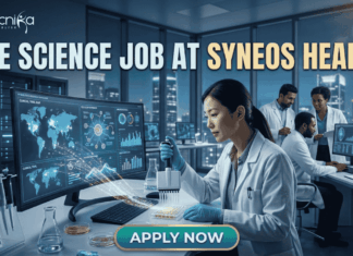 Top Life Science Job at Syneos Health – Central Monitor Role Hiring Now! Life Science Job at Syneos Health | Central Monitor Role. A professional promotional graphic for a "Life Science Job at Syneos Health" featuring the Biotecnika logo at the top. The image depicts a female scientist in a white lab coat and blue gloves using a multichannel pipette on a microplate in a modern, high-tech laboratory. A large computer monitor in the foreground displays complex global data visualizations, including a world map with interconnected nodes, cellular diagrams, and data graphs. In the background, other researchers are seen working at their stations. The laboratory features large glass windows that reveal a glowing city skyline at night. A large, prominent "APPLY NOW" button is centered at the bottom.